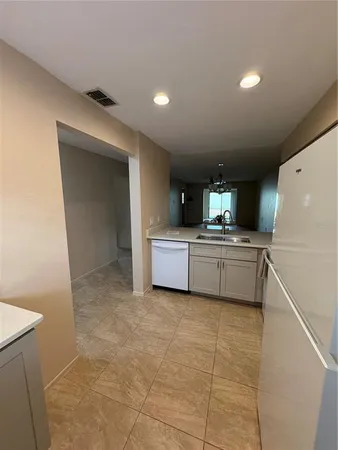 a kitchen with a sink a counter top space cabinets and stainless steel appliances