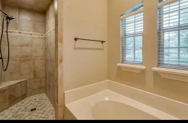 a bathroom with a granite countertop tub sink double and mirror
