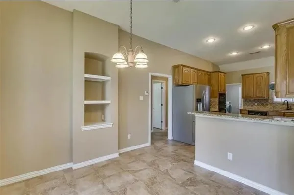 a large kitchen with stainless steel appliances granite countertop a sink and a refrigerator