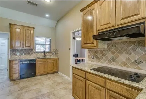 a kitchen with granite countertop a refrigerator stove and sink