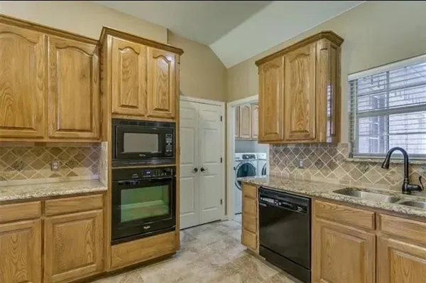 a kitchen with stainless steel appliances granite countertop a refrigerator stove and cabinets