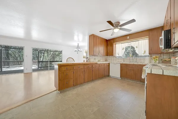 a kitchen with wooden cabinets a sink a window and appliances