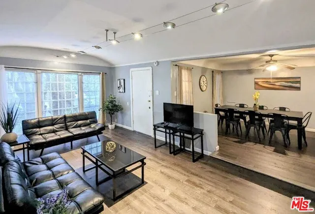 a living room with furniture a dining table and large windows