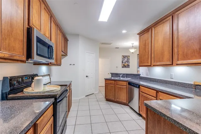 a kitchen with stainless steel appliances granite countertop a sink stove and cabinets