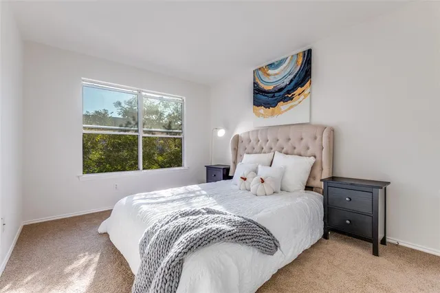 a bedroom with a bed and a painting on the wall