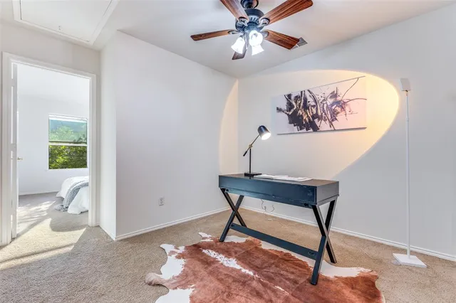 a view of a workspace with furniture and a window