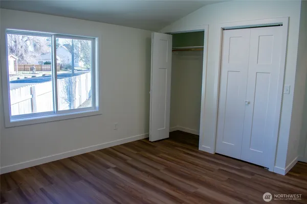 a view of a room with wooden floor and window
