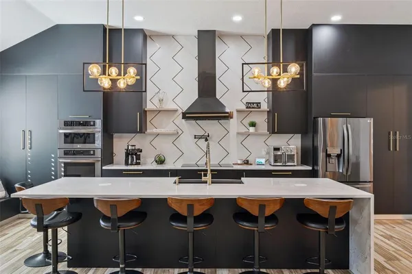 a kitchen with stainless steel appliances granite countertop a stove a sink and a refrigerator