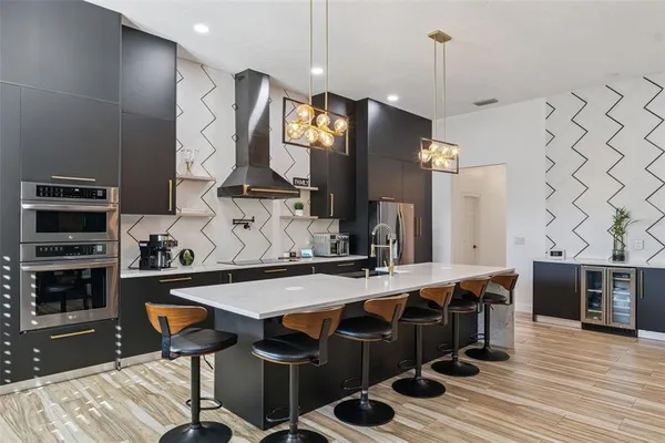 a kitchen with stainless steel appliances granite countertop a stove a sink and a refrigerator