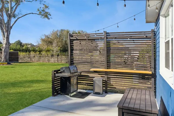 a view of a patio with table and chairs potted plants and a palm tree