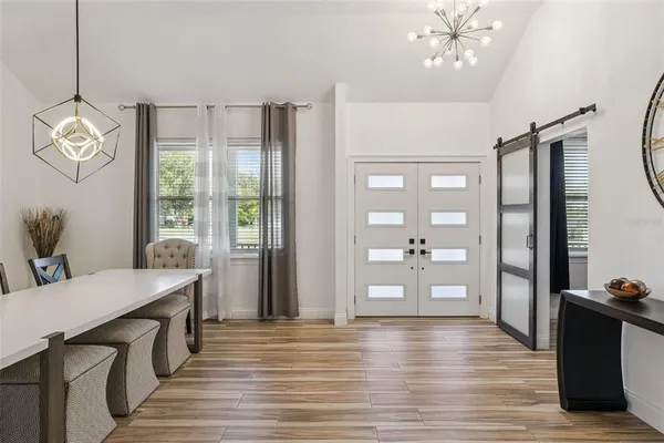 a view of a dining room with furniture a chandelier and wooden floor