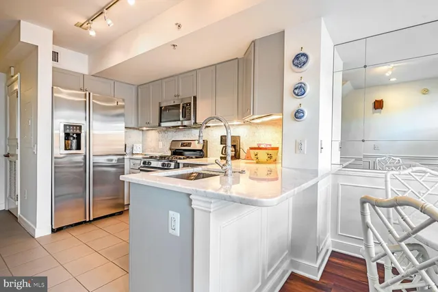 a kitchen with white cabinets and stainless steel appliances