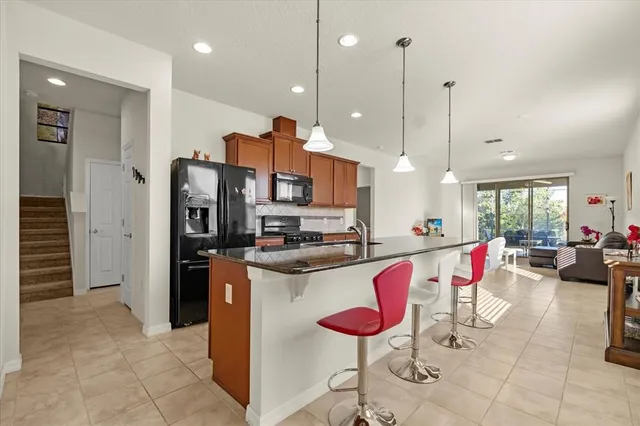 a kitchen with stainless steel appliances granite countertop a stove a sink and a refrigerator