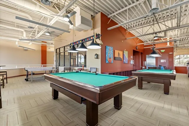 a room with pool table and windows