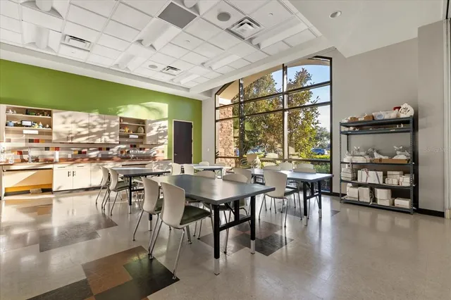 a dining room with lots of furniture and a large window