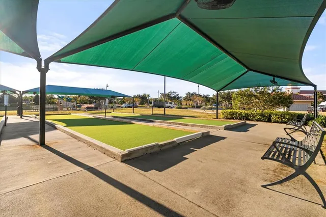 a view of a swimming pool with lawn chairs under an umbrella