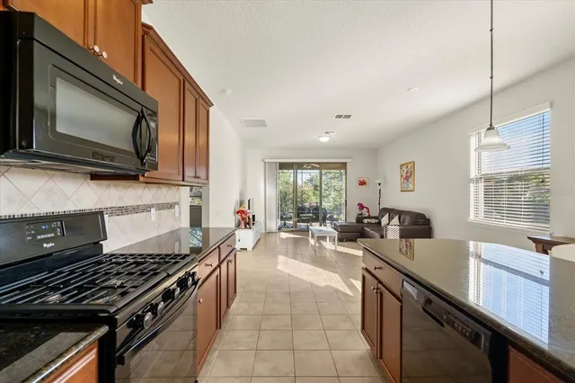 a kitchen with lots of counter top space a stove a sink a window and living room