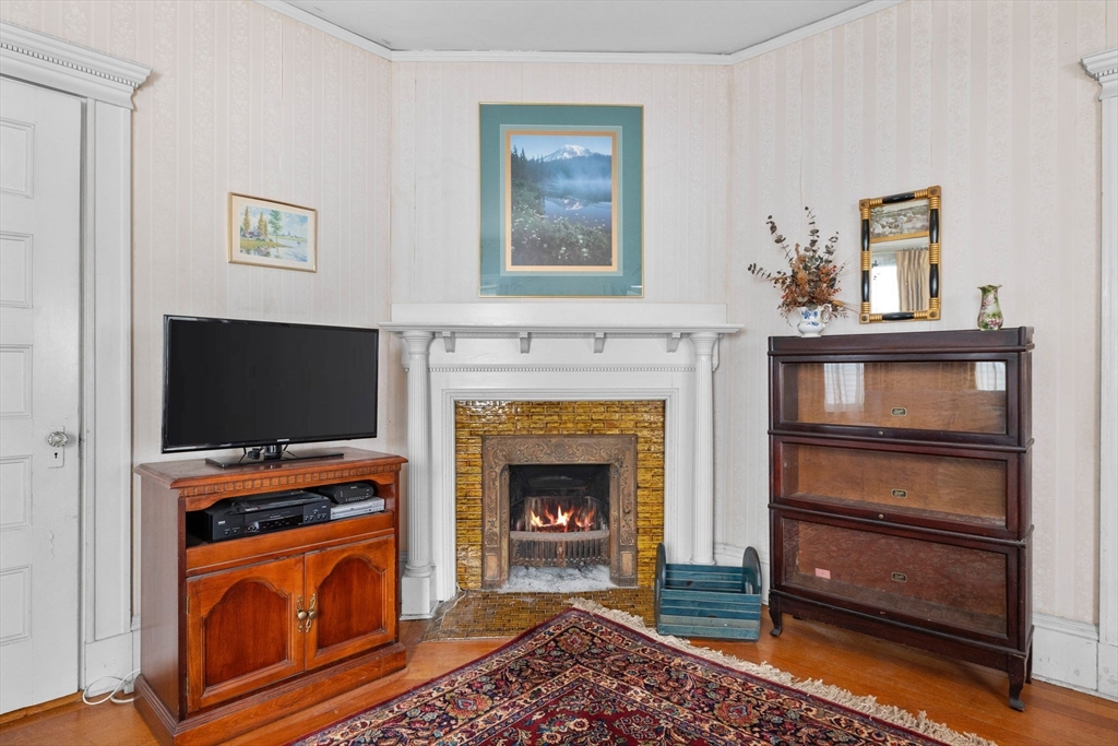 44 Walnut Street Everett, MA 02149 - Photo 11 of 38 a living room with a fireplace and a flat screen tv