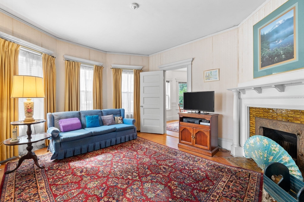 44 Walnut Street Everett, MA 02149 - Photo 3 of 38 a living room with furniture a flat screen tv and a fireplace