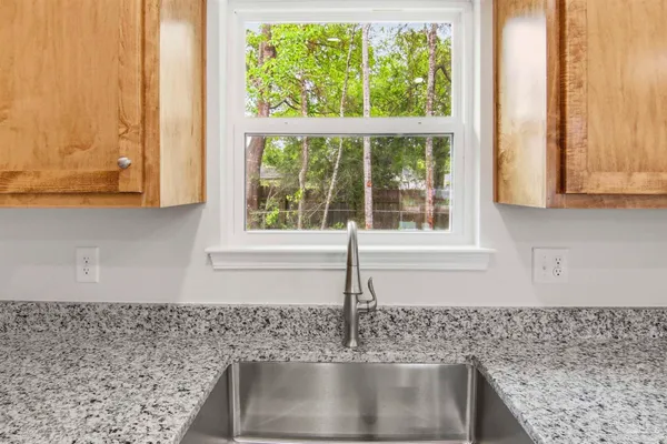 a kitchen with granite countertop a sink and a window
