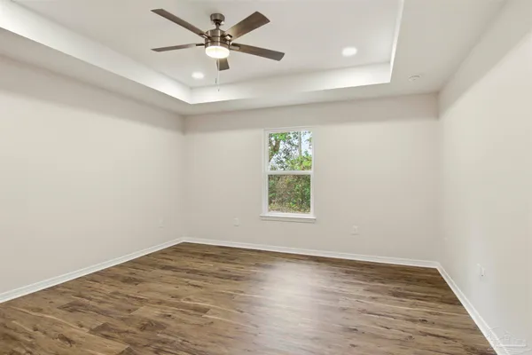 an empty room with a window and a fan