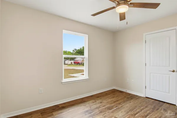 an empty room with a window and ceiling fan