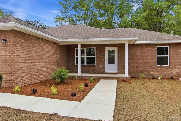 a view of brick house with potted plants in front of door
