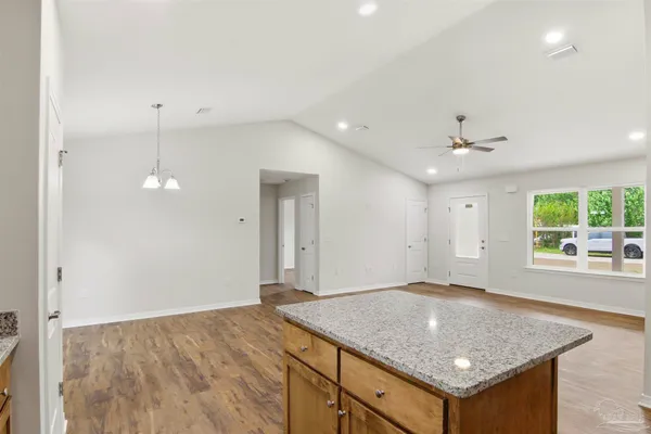 an empty room with a kitchen and windows