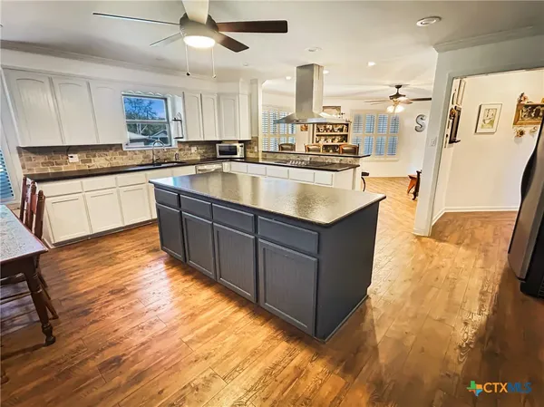 a large kitchen with stainless steel appliances kitchen island granite countertop a sink and cabinets