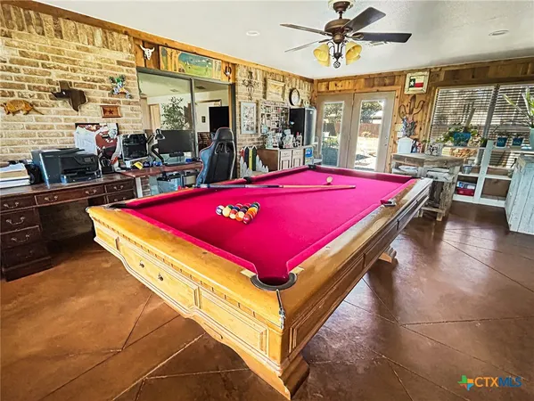 a room with pool table and windows