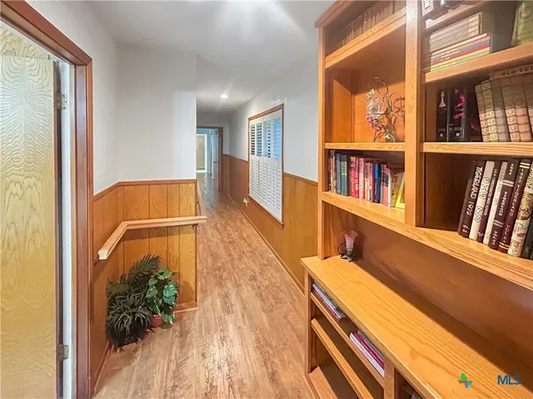 a hallway with a book shelf in it