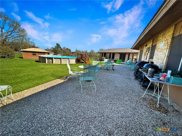 a view of a house with backyard and sitting area