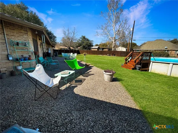 a view of a table and chairs in backyard of the house