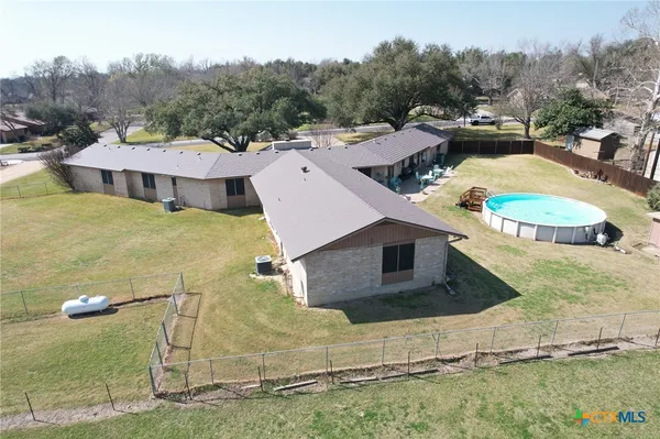an aerial view of a house with a yard and lake view