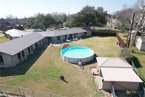 a view of a swimming pool with a patio and yard