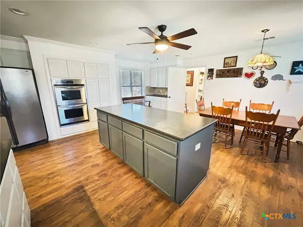 a large kitchen with kitchen island a large counter space appliances and cabinets