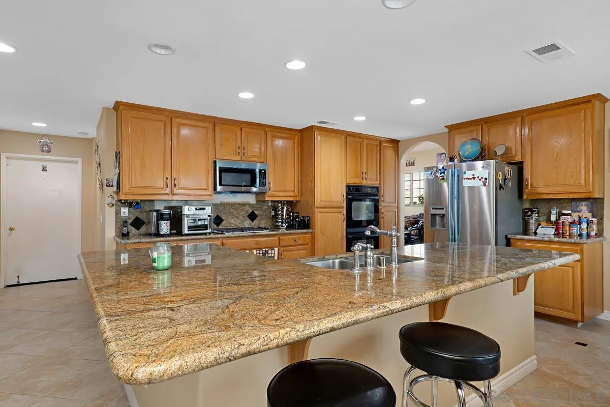 1707 Horizon Heights Circle El Cajon, CA 92019 - Photo 4 of 26 a kitchen with stainless steel appliances granite countertop a sink a stove and a refrigerator with wooden floor