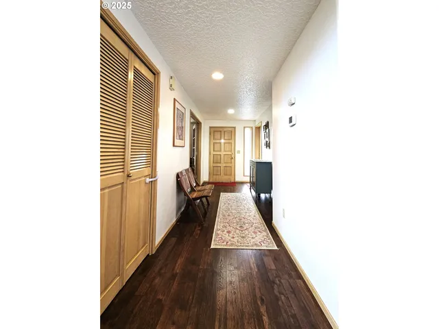 a hallway with a large window and wooden floor