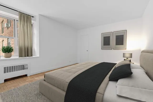 a bedroom with a bed and a window with balcony view