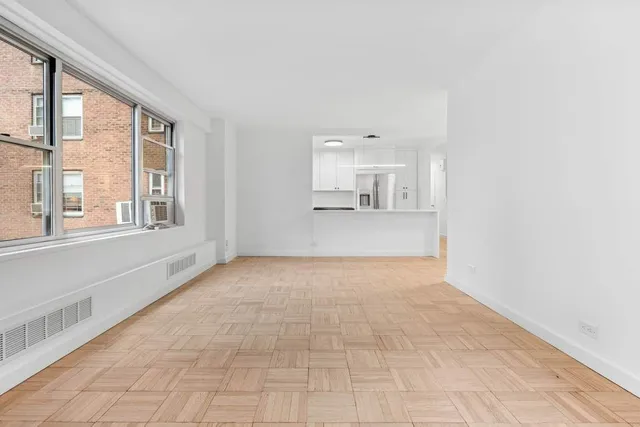 a view of empty room with wooden floor and windows