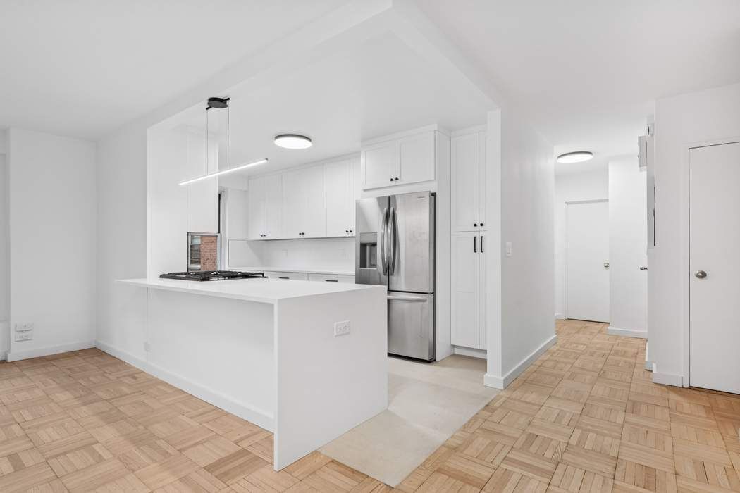 475 FDR Drive, Unit L804 Manhattan, NY 10002 - Photo 9 of 17 a kitchen with a refrigerator sink and cabinets