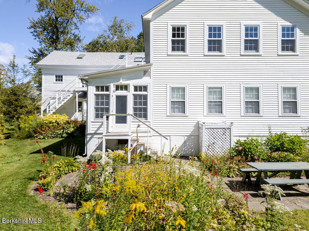 454 Main Road, Unit 2 Monterey, MA 01245 - Photo 4 of 30 a front view of a house with a yard and potted plants