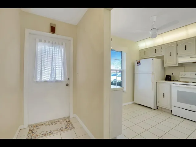 a view of a kitchen with white cabinets and refrigerator
