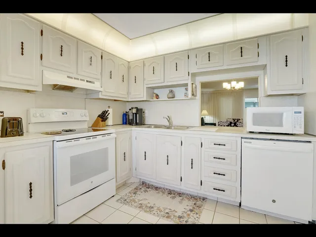 a kitchen with white cabinets and white appliances