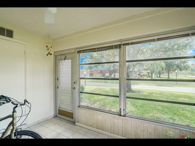a view of a room that has a window and wooden floor