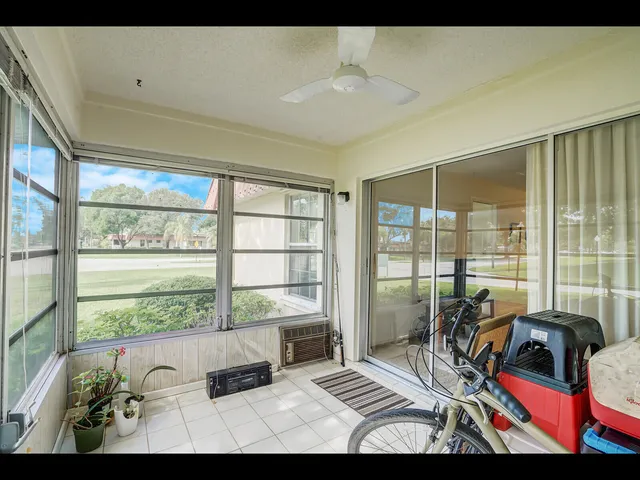 a view of an empty room with wooden floor and floor to ceiling windows