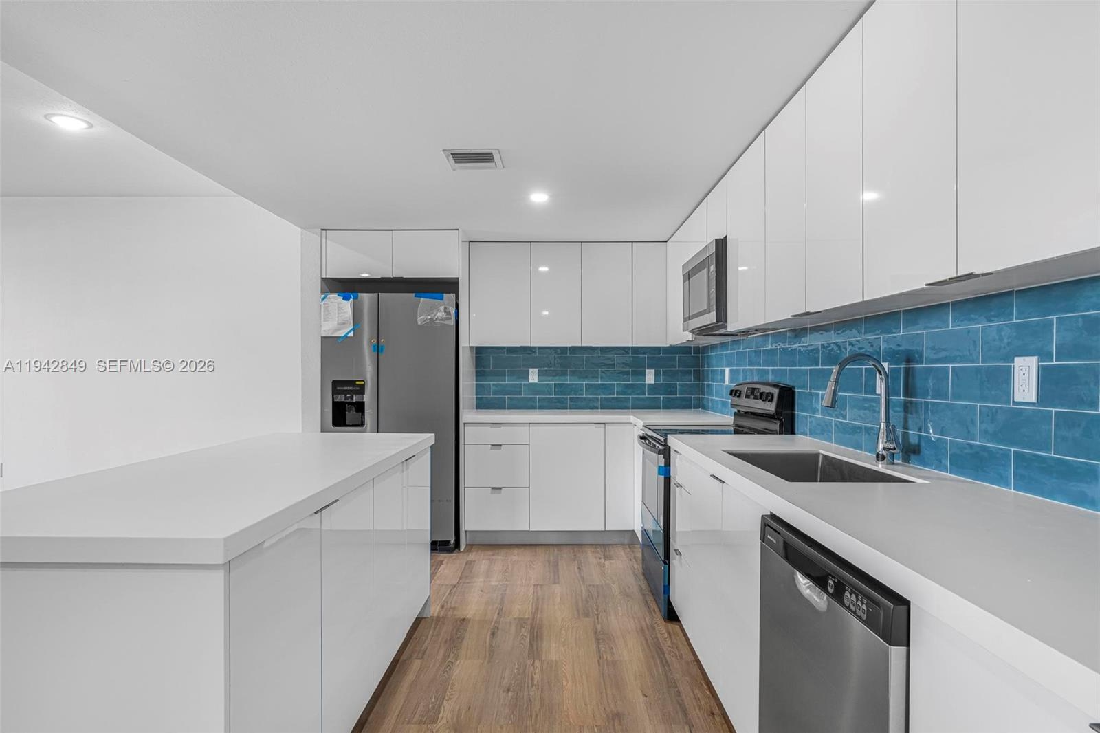 16955 Southwest 100th Avenue, Unit 9 Miami, FL 33157 - Photo 4 of 17 a kitchen with a sink a stove and cabinets