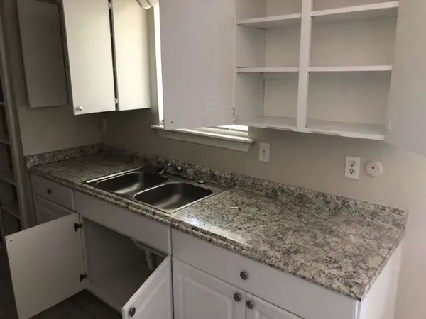a kitchen with sink stove and cabinets