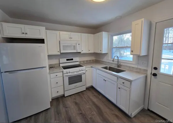a kitchen with cabinets appliances a sink and a window