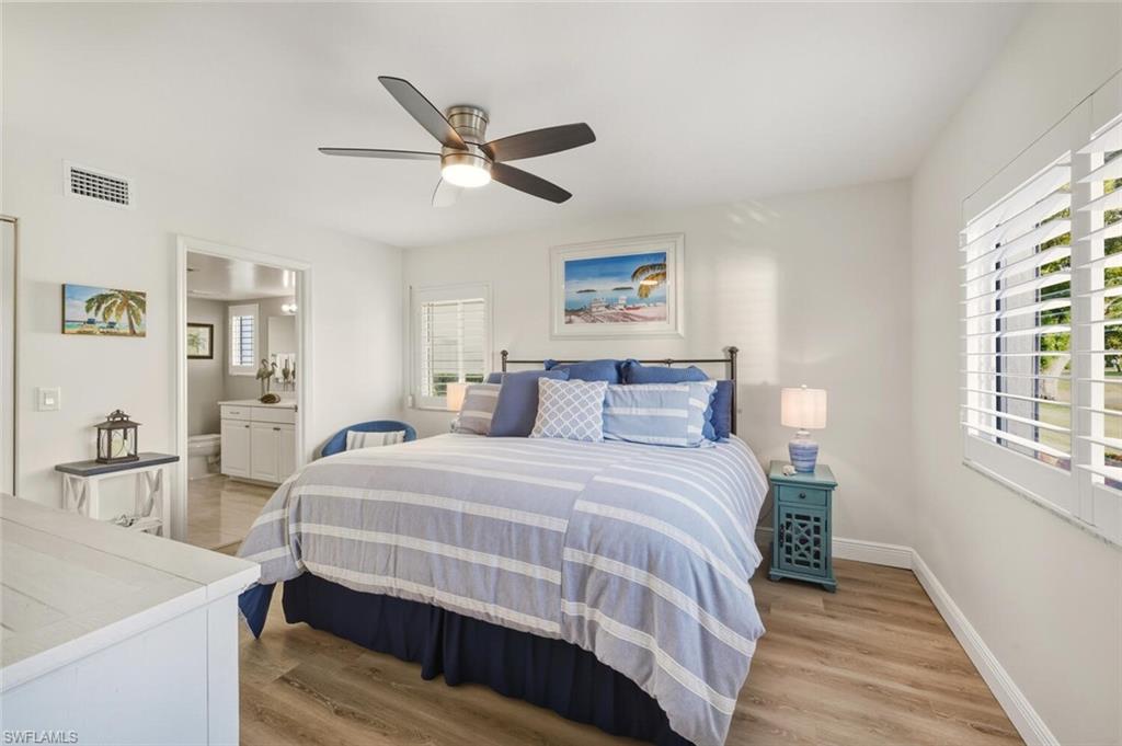 7772 Emerald Circle, Unit 101 Naples, FL 34109 - Photo 16 of 37 a bedroom with a bed and wooden floor